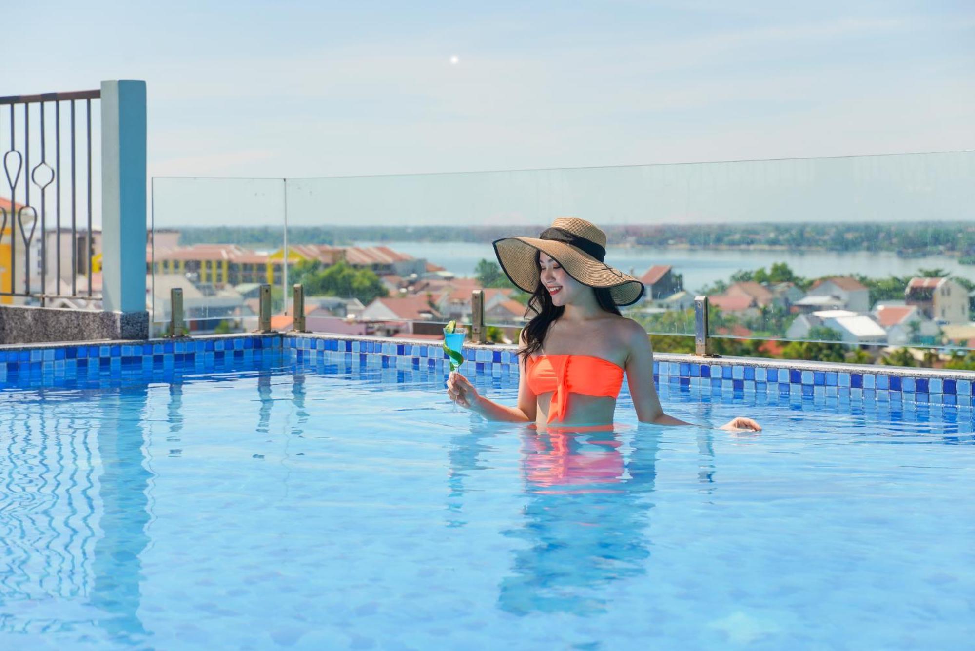 Cozy Savvy Boutique Hotel Hoi An Eksteriør billede A woman in a swimming pool